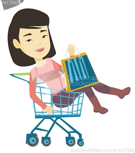 Image of Happy woman riding by shopping trolley.