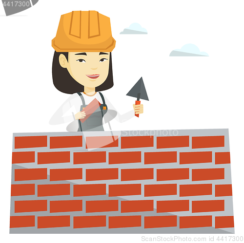 Image of Bricklayer working with spatula and brick.