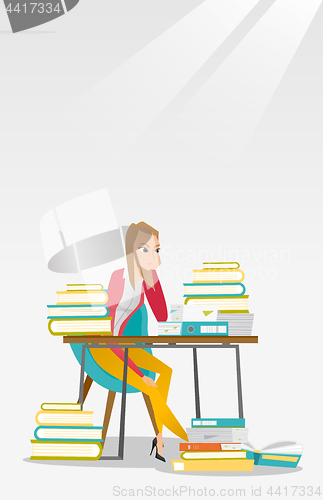 Image of Student sitting at the table with piles of books.