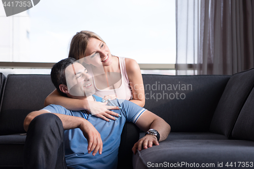 Image of young handsome couple hugging on the sofa