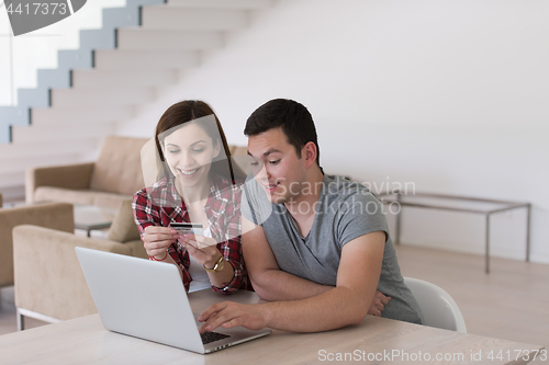 Image of happy young couple buying online