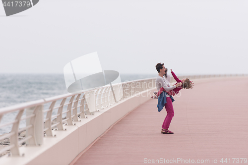 Image of mother and cute little girl on the promenade by the sea