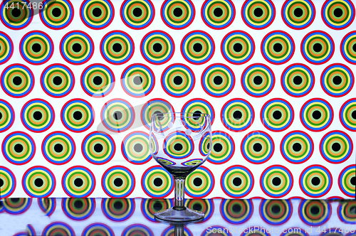 Image of glass wine glass on colored background circles