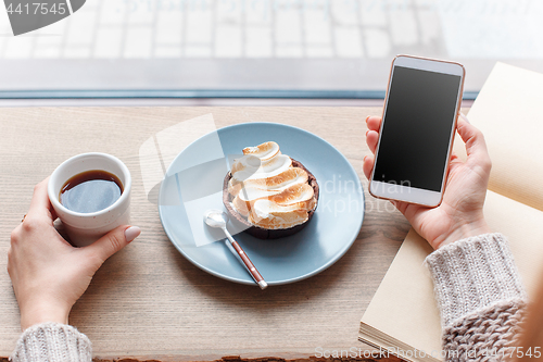 Image of Cup of coffee, branch of tree, wooden windowsill