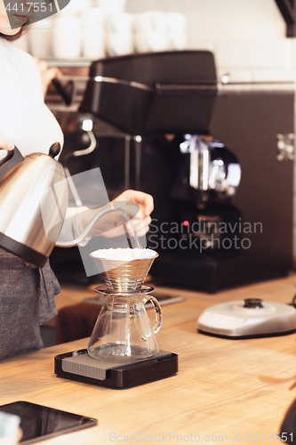 Image of Hand drip coffee, Barista pouring water on coffee ground with filter