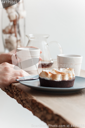 Image of Cup of coffee, branch of tree, wooden windowsill