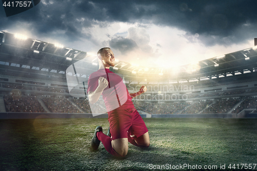 Image of Happiness football player after goal on the field of stadium