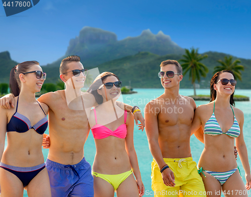 Image of smiling friends in sunglasses on summer beach