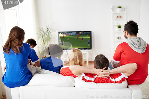 Image of football fans watching soccer game on tv at home