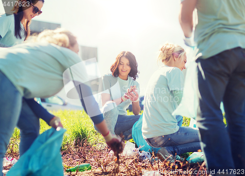 Image of volunteers with garbage bags cleaning park area