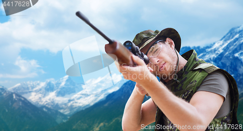 Image of soldier or hunter with gun aiming or shooting