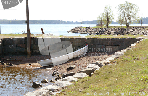 Image of White rowing boat on stony beach on Suomenlinna island