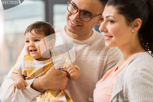 Image of happy family with baby daughter at home