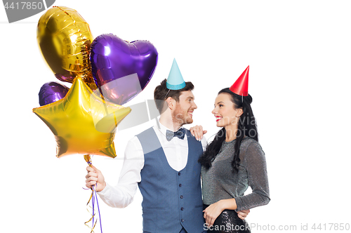 Image of happy couple with party caps and balloons