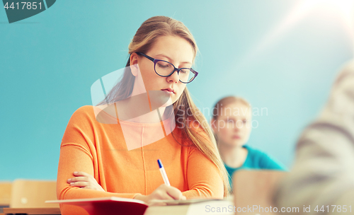 Image of group of students with books writing school test