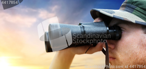 Image of close up of soldier face looking to binocular