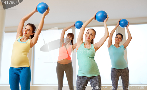 Image of pregnant women training with exercise balls in gym