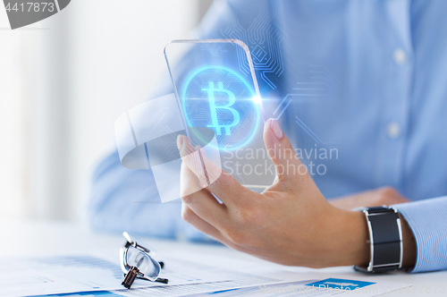 Image of close up of bitcoin on transparent smartphone