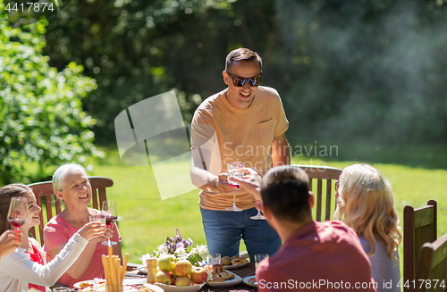 Image of happy family having dinner or summer garden party