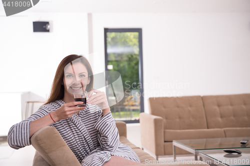 Image of young woman in a bathrobe enjoying morning coffee