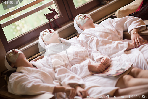 Image of women is getting facial clay mask at spa