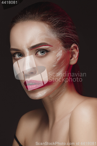 Image of Fashion Model Girl with colored face painted. Beauty fashion art portrait of beautiful woman with colorful abstract makeup.