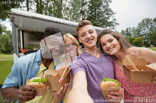 Image of happy friends taking selfie at food truck