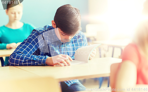 Image of group of students with books writing school test