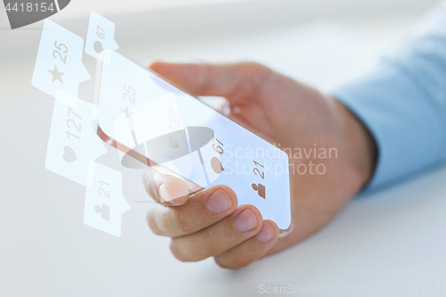 Image of hand with social media icons on smartphone