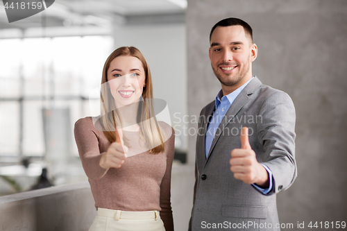 Image of businesswoman and businessman showing thumbs up