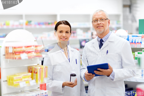 Image of apothecaries with tablet pc and drug at pharmacy