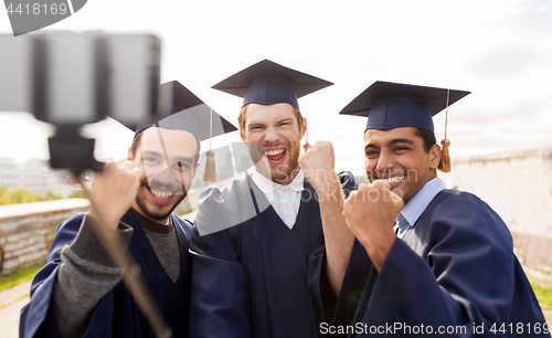 Image of happy male students or graduates taking selfie