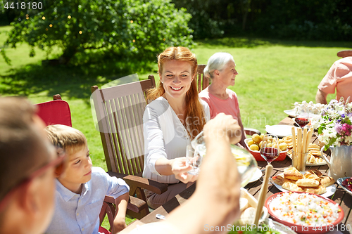 Image of happy family having dinner or summer garden party