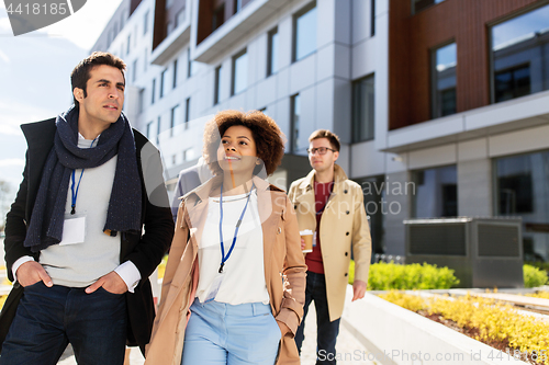 Image of people with coffee and conference badges in city