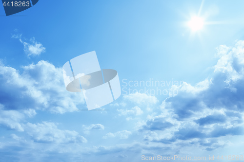 Image of bright blue sky with sun and clouds background