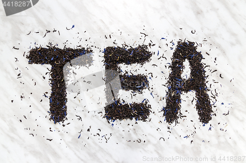 Image of The word TEA written with black Earl Gray leaves
