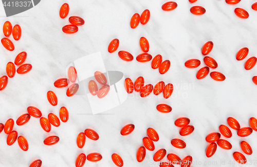 Image of Red shiny pills on marble background
