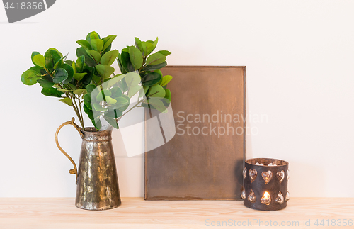 Image of Vintage home decor composition with metal objects and green plan