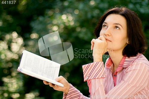 Image of female reading in park
