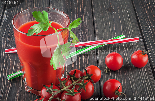 Image of Glass of tomato juice on wooden table