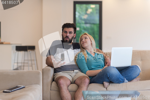 Image of young happy couple relaxes in the living room