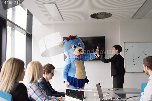 Image of boss dresed as bear having fun with business people in trendy of