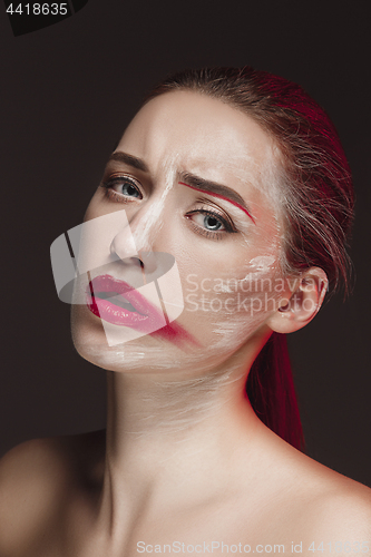 Image of Fashion Model Girl with colored face painted. Beauty fashion art portrait of beautiful woman with colorful abstract makeup.