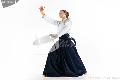 Image of Aikido master practices defense posture. Healthy lifestyle and sports concept. Woman in white kimono on white background.
