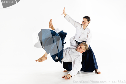 Image of Man and woman fighting at Aikido training in martial arts school