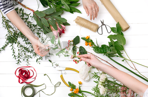 Image of Female florist making beautiful bouquet at flower shop