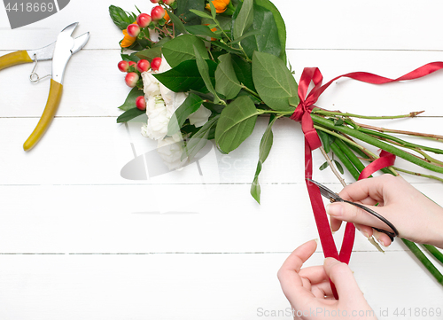 Image of Female florist making beautiful bouquet at flower shop