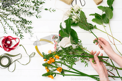 Image of Female florist making beautiful bouquet at flower shop