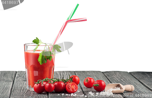 Image of Glass of tomato juice on a wooden table