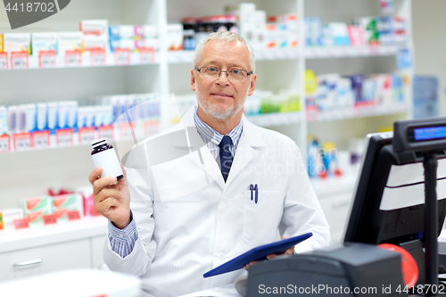 Image of senior apothecary with drug at pharmacy